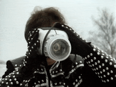 a person wearing studded gloves is taking a picture