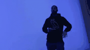 a man is dancing in front of a blue wall .
