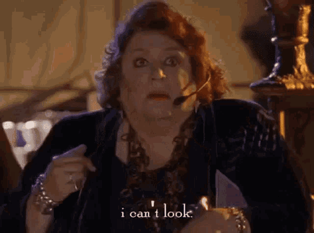 a woman with red hair is wearing a headset and saying `` i can t look '' .