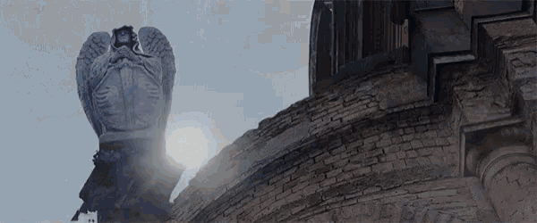 a statue of an angel on top of a brick building .