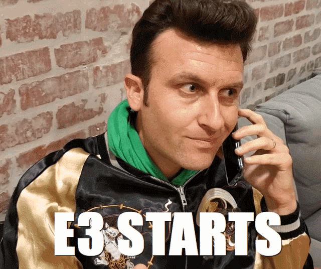 a man talking on a cell phone with the words " e3 starts " on the bottom