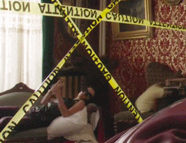 a woman is laying on a couch in a living room with a caution tape around her