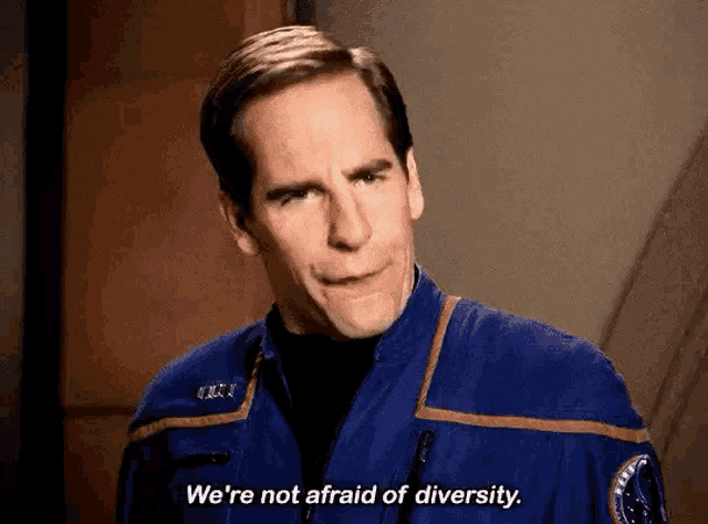 a man in a space suit is making a funny face and saying we 're not afraid of diversity .