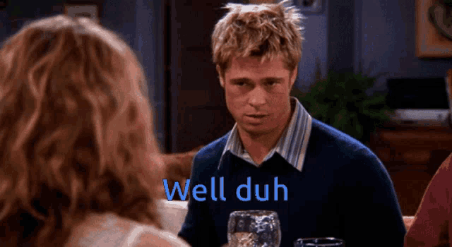 a man in a blue sweater is talking to a woman and the words well duh are on the screen