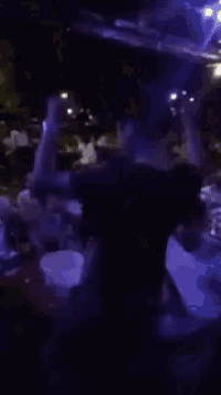 a blurry picture of a crowd of people dancing in a dark room