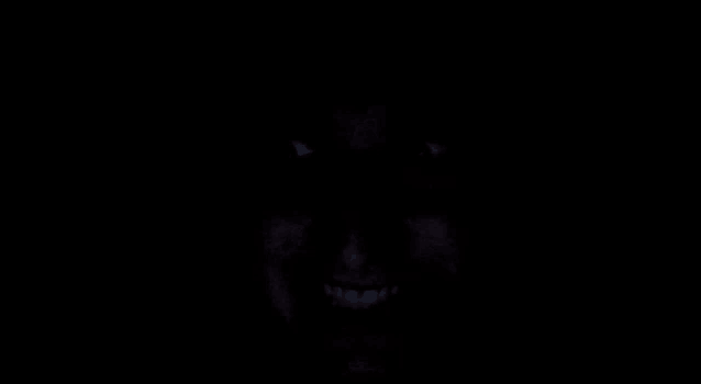 a close up of a person 's face in the dark with their eyes glowing