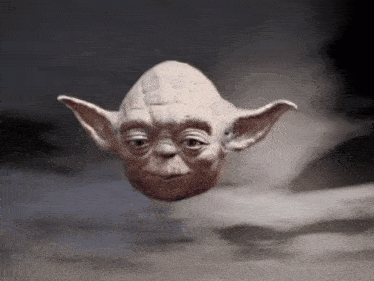 a close up of a statue of yoda floating in the air