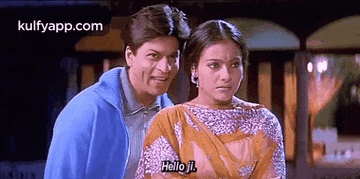 a man and a woman are standing next to each other and the woman is saying `` hello j. ''