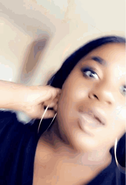 a close up of a woman 's face wearing hoop earrings .