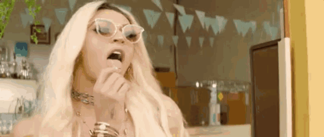 a woman wearing sunglasses and a wig is eating something .