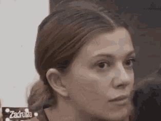 a close up of a woman 's face with a serious look on her face .