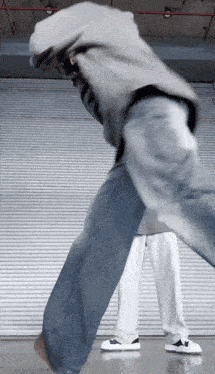 a man in a grey hoodie and jeans is dancing