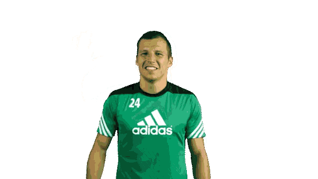 a man wearing a green adidas shirt is waving his hand