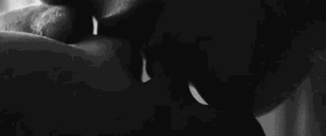 a black and white photo of a woman 's mouth with a spoon in it .