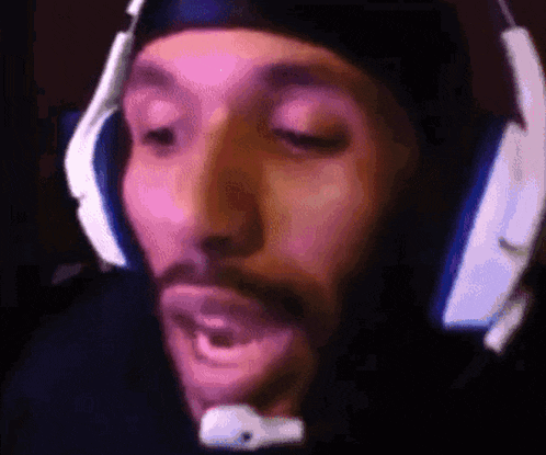 a man with a beard wearing headphones and a headset .