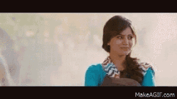 a woman in a blue shirt is making a funny face on make a gif