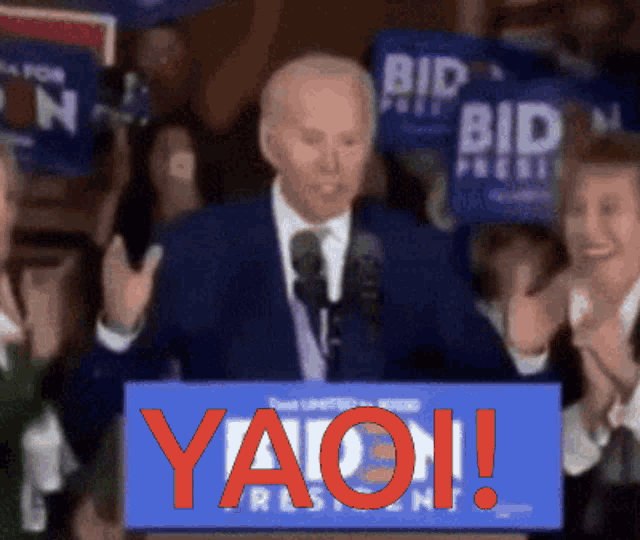 a man stands behind a podium that says yaoi