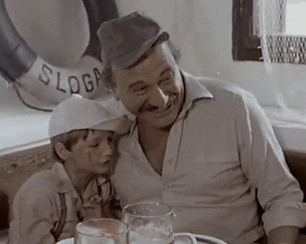 a man and a boy sit at a table with a life preserver on the wall that says slogan