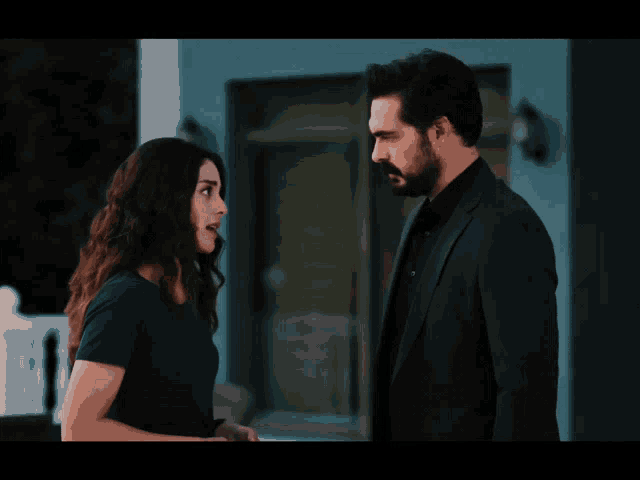 a man and a woman looking at each other in front of a house