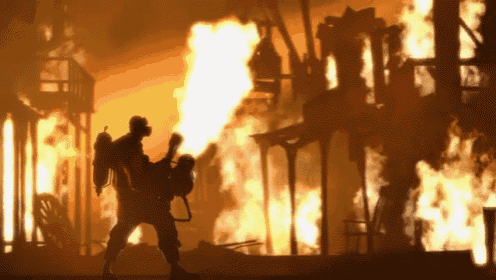 a silhouette of a fireman standing in front of a burning building