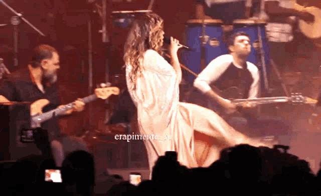 a woman singing in front of a microphone with the name erapimentes on the bottom left