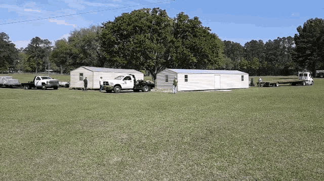 a row of trailers are parked in a grassy area