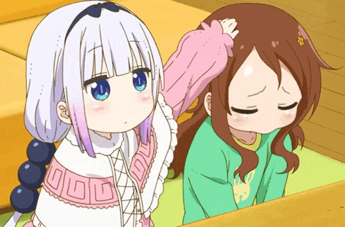 a girl with blue eyes is petting another girl 's head while another girl looks down