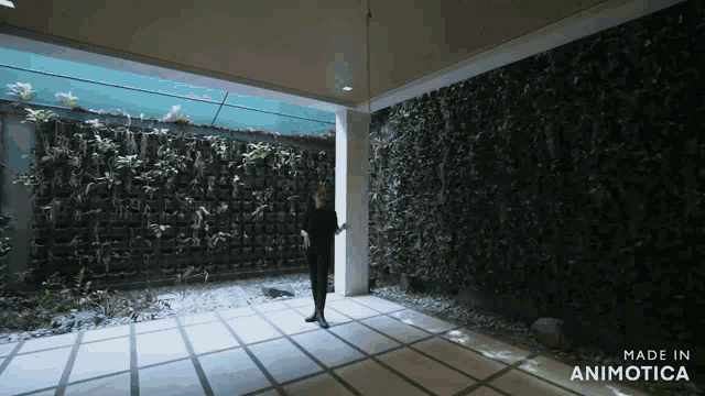 a video of a woman standing in front of a wall that says made in animatica
