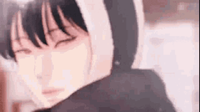 a close up of a person 's face with their eyes closed and a hoodie on .