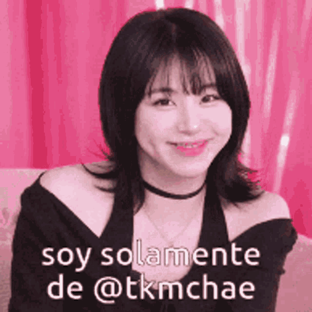 a woman with a choker on her neck is smiling with the words soy solamente de @tkmchae below her .