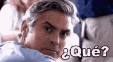 a man is sitting on a plane with a serious look on his face and the words `` qué ? '' written above him .