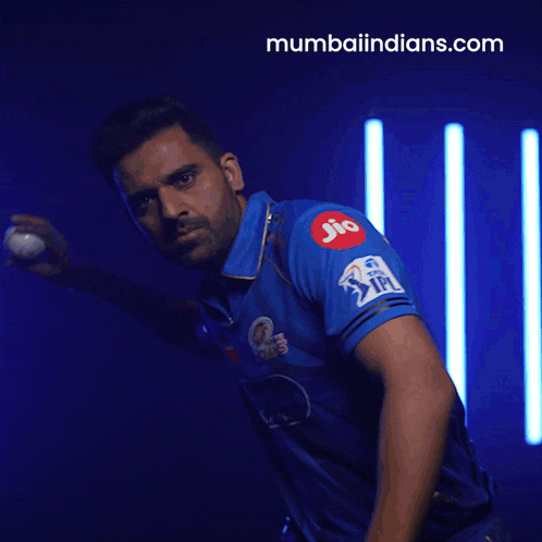 a man in a blue shirt is throwing a ball and the website mumbaiindians.com is visible in the background