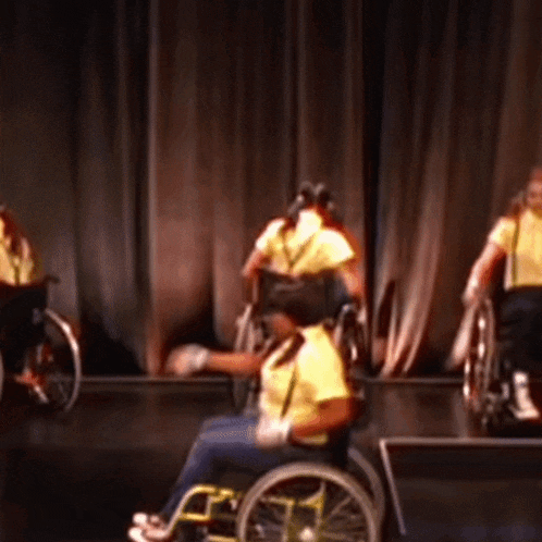 a group of people in wheelchairs perform on a stage