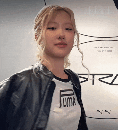 a woman wearing a puma t-shirt and a black jacket