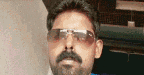 a man with a beard is wearing sunglasses and looking at the camera
