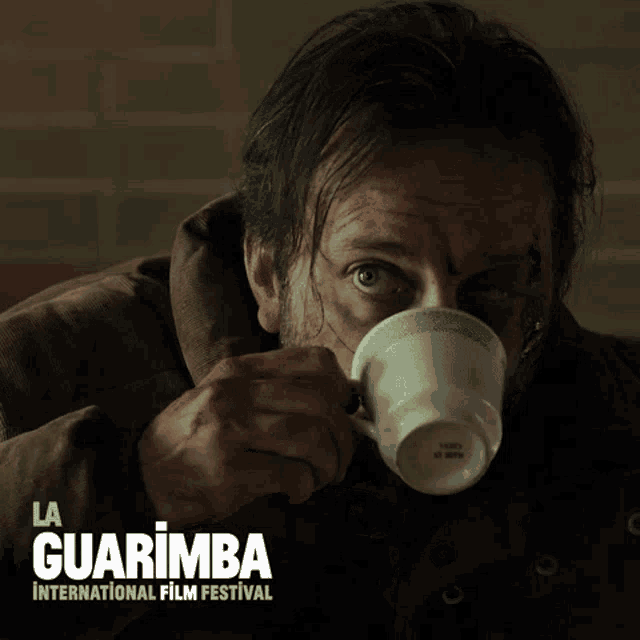 a man drinking from a cup with the words la guarimba international film festival on the bottom
