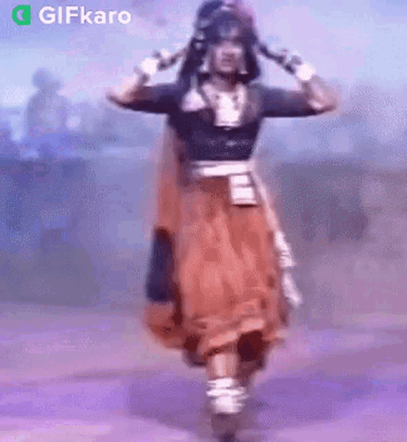 a woman in a costume is dancing on a stage with a purple background .