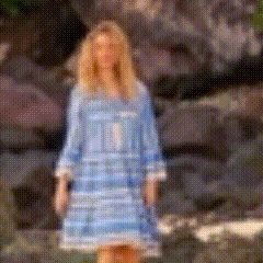 a woman in a blue dress is standing in front of a wall .