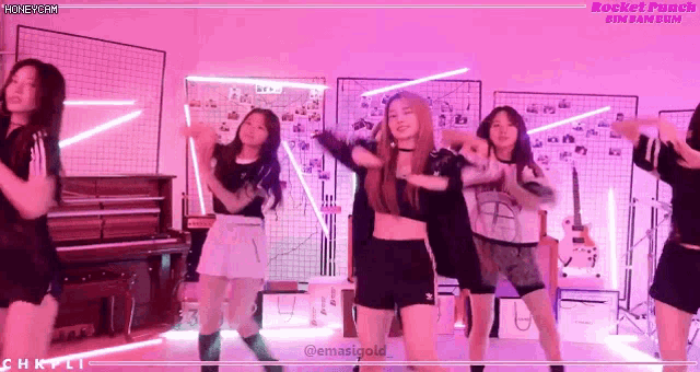 a group of girls are dancing in front of a piano with the words rocket punch in the corner