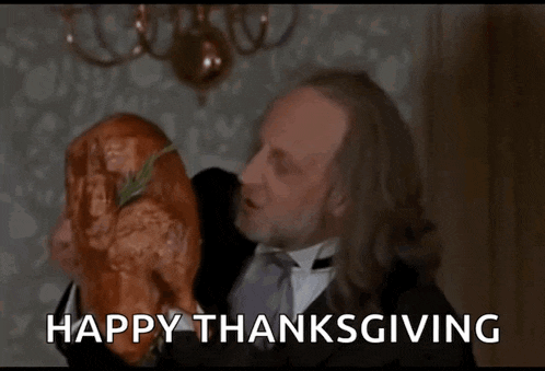 a man in a tuxedo is eating a large turkey with the words happy thanksgiving written below him .