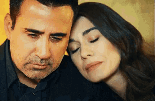 a man is crying while a woman looks on