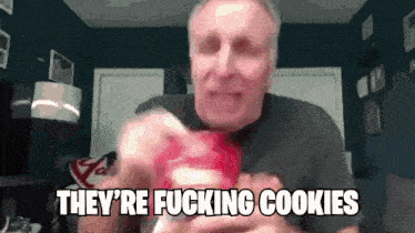 a man is eating a cookie and saying they 're fucking cookies .