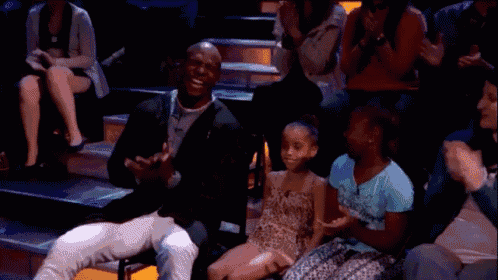 a man and a little girl are sitting in a theatre applauding