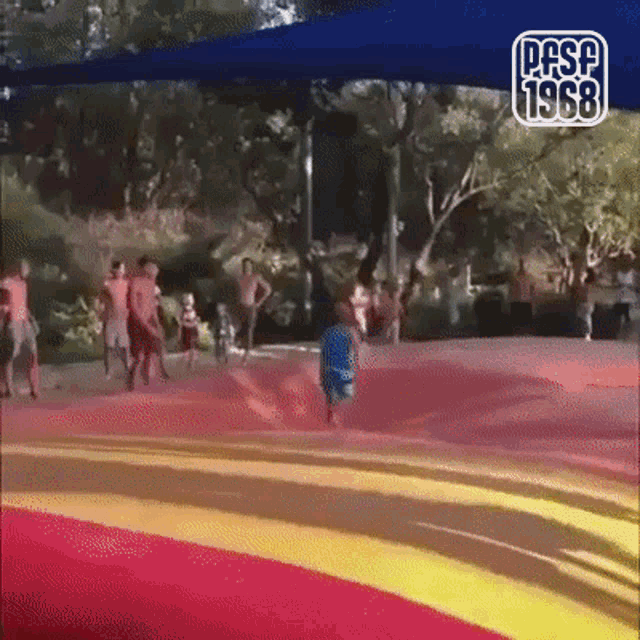 a group of people are playing on a bouncy mat with the year 1968 on the bottom right