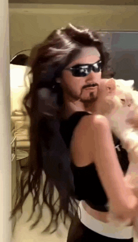 a woman with long hair and a fake beard is holding a cat .