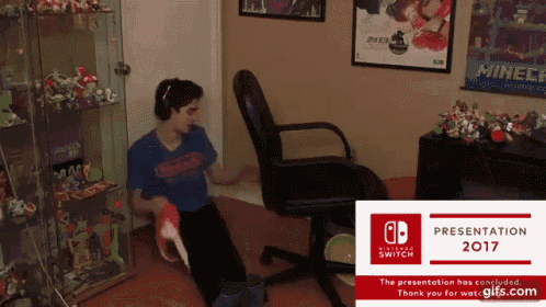 a man sitting in a chair next to a sign that says nintendo switch