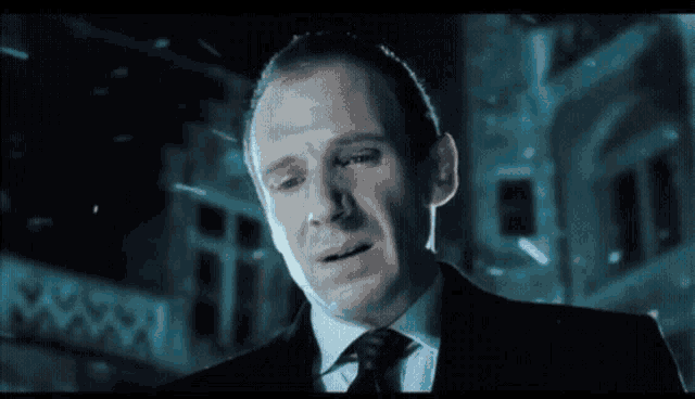 a man in a suit and tie is standing in front of a building