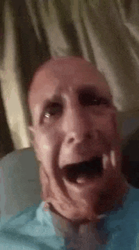 a man with a beard is making a funny face with his mouth wide open .