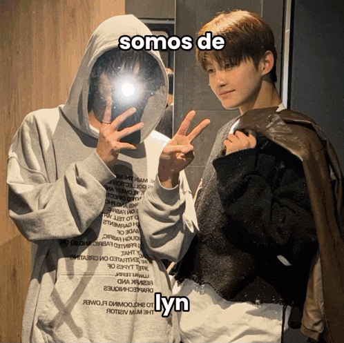 a man in a hoodie takes a picture of himself in a mirror with the words somos de yn above him