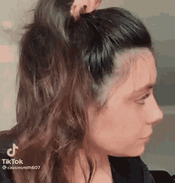 a close up of a woman 's face with her hair in a bun .